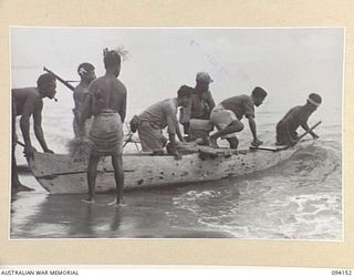 TINIAN, BOUGAINVILLE, 1945-07-18. NETHERLANDS EAST INDIES ARMY PERSONNEL GETTING INTO A NATIVE CANOE ON SHORE FOR TRANSFER TO THE RESCUE VESSEL ML1327, A MOTOR LAUNCH USED BY THE ALLIED ..
