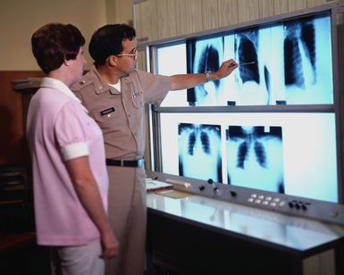 STAFF Sergeant Richard J. Segrist, non-commissioned officer in charge, Medical Co. B, Tripler Army Medical Center, looks through a Phoroptor to examine a patient's eyes