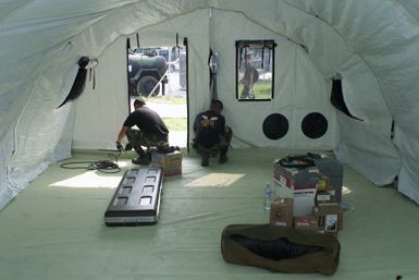 U.S. Air Force STAFF Sergeants Tanny Valdes and Philip Taijeron from Guam, deployed to the 3rd Air Expeditionary Group at Kwang-Ju Air Base, Republic of Korea, install electrical outlets in the medical services Small Shelter System on Sept. 3, 2004. (U.S. Air Force photo by Technical Sergeant Corey A. Clements) (Released)