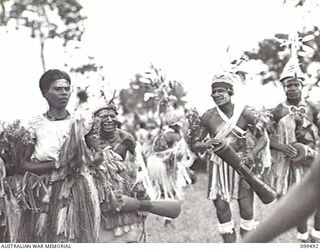 LAE, NEW GUINEA, 1945-12-25. A DANCE IN PROGRESS AT THE NATIVE SING-SING HELD AT THE MALAHANG NATIVE LABOUR COMPOUND TO CELEBRATE CHRISTMAS. MANY ALLIED AND AUSTRALIAN NEW GUINEA ADMINISTRATIVE ..