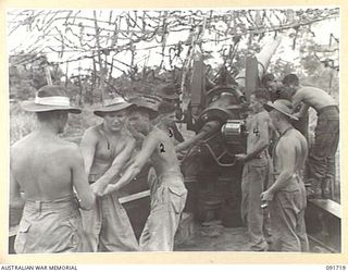 HAWAIN, WEWAK AREA, NEW GUINEA. 1945-05-09. A 2/3 FIELD REGIMENT GUN CREW LOADING A 95 POUND SHELL INTO A "LONG TOM" 155MM GUN DURING THE ATTACK AGAINST THE MAIN JAPANESE FORTRESS AT WEWAK. ..
