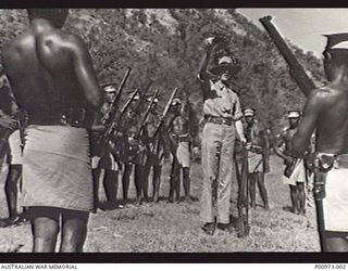 NATIVE CONSTABULARY RECRUITS OF THE  NEW GUINEA POLICE FORCE UNDERGOING TRAINING IN ELEVATION AT THE POLICE TRAINING DEPOT. THE INSTRUCTOR IS THE OFFICER IN CHARGE, ALEXANDER SINCLAIR