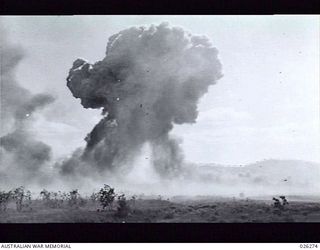 PAPUA. 1942-08-18. ALLIED BOMBERS EXPLODING ON SEVEN MILE AERODROME NEAR PORT MORESBY AFTER BEING HIT IN A BOMBING RAID BY TWENTY-FOUR JAPANESE BOMBERS