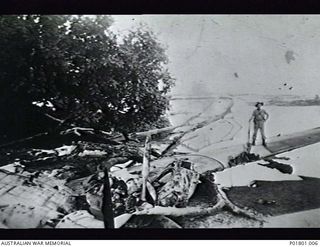 Jacquinot Bay, New Britain. c.1945. An Australian soldier, Len Geary, on the wing of a crashed A24 Consolidated Catalina aircraft on the edge of Jacquinot Bay Catalina Base. The crew were buried as ..