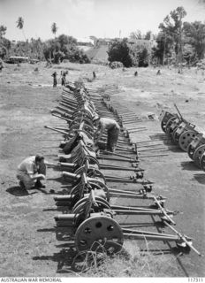 NAURU ISLAND. 1945-09-16. ARMOURERS OF THE 31/51ST INFANTRY BATTALION INSPECTING JAPANESE MOUNTAIN GUNS CAPTURED BY MEMBERS OF THE UNIT SOON AFTER THEY HAD OCCUPIED THE ISLAND
