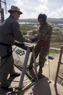 US Navy (USN) CHIEF PETTY Officer (CPO) Jeremy Logan (left), assigned to Explosive Ordnance Disposal Mobile Unit 5 (EODMU-5) gives last-minute advice to Royal Australian Navy (RAN) Lieutenant Commander (LCDR) Michael Maley, before he goes over the side of a wall during a fast rope exercise conducted at Santa Rita Naval Base, Guam (GU), during the Annual Multi-national Explosive Ordnance Disposal (EOD) Exercise known as TRICARB 2006." The Exercise brings together EOD Units from the US, Australia and Singapore