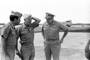 ADM Sylvester R. Foley, Jr., commander in chief, U.S. Pacific Fleet, (center), prepares to depart after a tour to inspect the damage wreaked by hurricane Iwa