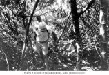 Lauren R. Donaldson (front) and Hill Williams walking along a trail on Bikini Island, summer 1964