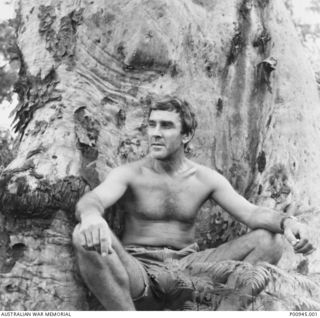 SANANANDA, NEW GUINEA. 1942-11. SERGEANT FRANK HODGKINSON, OFFICIAL WAR ARTIST, RELAXING IN FRONT OF A LARGE TREE, AFTER THE KOKODA TRAIL CAMPAIGN. (DONOR K. HODGKINSON)