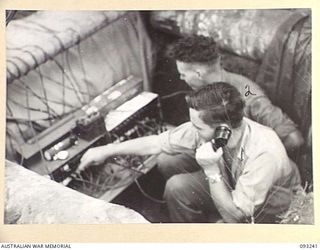 CHABAI/SORAKEN AREA, BOUGAINVILLE, 1945-06-16. A DUG-IN SIGNAL SWITCH BOARD AT 26 INFANTRY BATTALION (AIF) TACTICAL HEADQUARTERS. IDENTIFIED PERSONNEL ARE:- SIGNALMAN T. FAEHRMAN (1); SGT N.L. ..