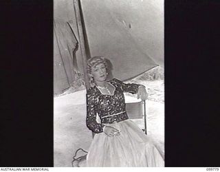 TOROKINA, BOUGAINVILLE, 1945-11-03. PRIVATE G. J. BUCKHAM, FEMALE IMPERSONATOR, RELAXING BETWEEN ACTS DURING A SHOW STAGED FOR TROOPS BY THE KOOKAROOS CONCERT PARTY, AUSTRALIAN ARMY AMENITIES ..