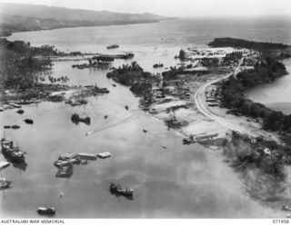 AN AERIAL VIEW TOWARDS THE OCEAN SHOWING SHIPPING AND PORT INSTALLATIONS AT THE HARBOUR