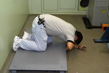 Mr. Lance Hamura, an employee from Xerox Company prepares a support stand for a printer installment inside a portable van, at the Combat Camera Center at Camp H.M. Smith, Hawaii (HI), during Operation IRAQI FREEDOM