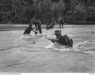 BUT AREA, NEW GUINEA. 1945-03-17. MEMBERS OF THE 2/2ND INFANTRY BATTALION CROSS THE SWIFT FLOWING NINAHAU RIVER DURING THEIR ADVANCE TO BUT. IDENTIFIED PERSONNEL ARE: VX44906 LIEUTENANT- COLONEL ..
