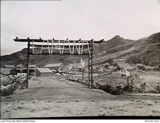 Garoka, New Guinea, 1945-05. The main gateway to the RAAF Aircrew Rest Camp, showing the camp's name 'Lamana', meaning 'Eternal Springs', spelled out in lengths of bamboo above the entrance. In the ..