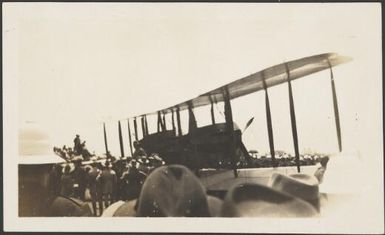 Biplane surrounded by onlookers, ca. 1928