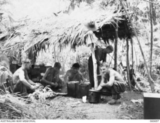 FINSCHHAFEN, NEW GUINEA. 1943-10-30. COOKS AND COOKHOUSE OF THE SIGNALS SECTION, HEADQUARTERS, 26TH AUSTRALIAN INFANTRY BRIGADE. THEY ARE LEFT TO RIGHT: NX38950 SIGNALMAN J. LEGG OF BINGERA, NSW. ..