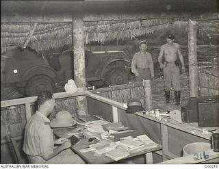 GOODENOUGH ISLAND, PAPUA. C. 1943-11. FLIGHT LIEUTENANT J. WATERS, A RAAF PUBLIC RELATIONS OFFICER, USING A TYPEWRITER AT HIS DESK WHILE WORKING AT VIVIGANI