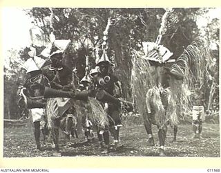 SONG RIVER, FINSCHHAFEN AREA, NEW GUINEA. 1944-03-26. FINSCHHAFEN BOYS PERFORMING THEIR SIASSI DANCE DURING A SING SING IN THE AUSTRALIAN NEW GUINEA ADMINISTRATIVE UNIT COMPOUND, HELD TO CELEBRATE ..