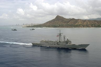 Passing Diamond Head, two US Navy (USN) SH-60F Seahawks, Light Helicopter Anti-Submarine Squadron 37 (HSL-37), Easy Riders, approach the Oliver Hazard Perry class Guided Missile Frigate USS CROMMELIN (FFG 37) to join the ship as it departs on a scheduled six-month deployment