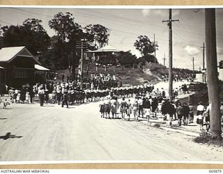 HERBERTON, QLD. 1944-04-25. GIRLS OF ST. MARY'S SCHOOL FOLLOWING THE TROOPS OF HEADQUARTERS, 6TH DIVISION AS THEY MARCH TO THE WAR MEMORIAL FOR THE ANZAC DAY SERVICE. SPECTATORS LINED THE SMALL ..