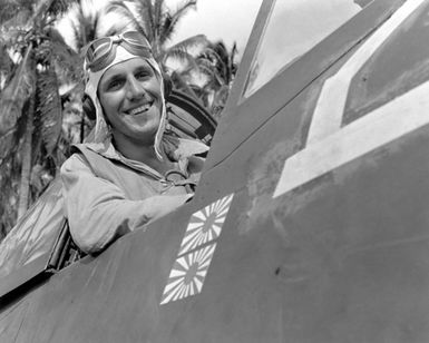 World War II (WWII) era photograph of US Marine Corps (USMC) Technical Sergeant (TSGT) Jack Pittman, Jr, taken at Russell Island, July 4, 1943 as he sits in the cockpit of a USMC F4U"CORSAIR"aircraft. TSGT Pittman is an Ace Pilot credited with 7 kills. His hometown is Amarillo, Texas