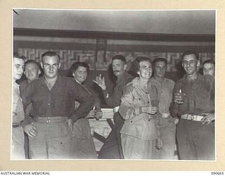 TOROKINA, BOUGAINVILLE. 1945-04-16. AUSTRALIAN MILITARY FORCES AND AUSTRALIAN ARMY MEDICAL WOMEN'S SERVICE PERSONNEL ENJOYING A SNACK DURING INTERVAL AT THE DANCE HELD AT THE OTHER RANKS CLUB, ..