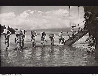 GILI GILI, NEW GUINEA, 1943-07-15. TROOPS OF THE 29TH AUSTRALIAN INFANTRY BRIGADE, 5TH AUSTRALIAN DIVISION, LOADING STORES AND AMMUNITION BY ROUND ROBIN PRIOR TO EMBARKING ON AMERICAN LCI'S ..