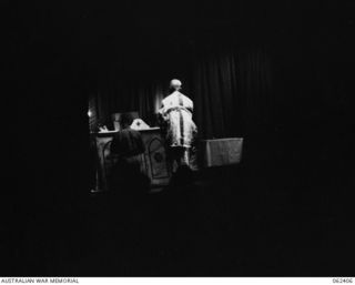 PORT MORESBY, PAPUA, NEW GUINEA. 1943-12-24. MIDNIGHT MASS CHRISTMAS EVE BEING CELEBRATED BY NX34952 CHAPLAIN F. H. GALLAGHER (1) WITH NX45303 PRIVATE J. A. SMITH (2) SERVING AT THE ALTAR MORESBY ..