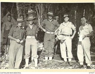JACQUINOT BAY, NEW BRITAIN. 1944-12-13. OFFICERS AND STAFF OF THE AUSTRALIAN NEW GUINEA ADMINISTRATIVE UNIT NATIVE COMPOUND NEAR THE MOUTH OF THE MALOPI RIVER. IDENTIFIED PERSONNEL ARE:- SERGEANT ..