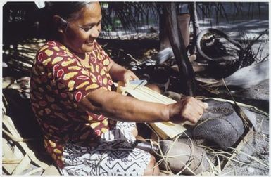 Stripping the pandanus leaves into fine strands for weaving using 'te bwere'