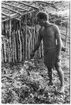 Man holding leaf in ritual, reciting spell