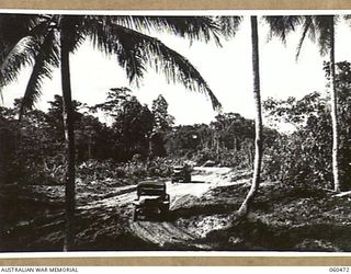 FINSCHHAFEN AREA, NEW GUINEA. 1943-11-09. PARTIALLY MADE ROAD FROM LANGEMAK BAY TO DREGER HARBOUR WHICH RUNS PARALLEL WITH THE EASTERN END OF THE NEW BOMBER AIRSTRIP, BEING BUILT JOINTLY BY THE ..