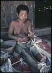 Weaving: woman makes skirt out of banana leaf fibers, some dyed red