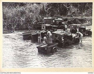 BOUGAINVILLE, 1945-07-31. TROOPS OF 29 INFANTRY BRIGADE WASHING THE HEAVY MUD OF THE BUIN ROAD OFF THEIR VEHICLES IN THE OGORATA RIVER AND FINDING NO SHORTAGE OF WATER