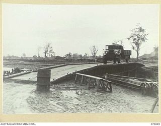LAE, NEW GUINEA. 1944-08-09. A 3 TON TRUCK CROSSING THE NEW BRIDGE ACROSS THE BUTIBUM RIVER WHICH IS BEING BUILT BY THE TROOPS OF THE 20TH FIELD COMPANY, TO REPLACE THE OLD WOODEN ONE WHICH WAS ..