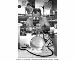 Ralph F. Palumbo examining algae under a microscope at the Eniwetok Marine Biological Laboratory, summer 1964