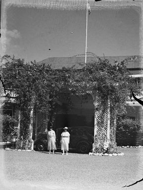 [Two women in front of cars and buildings]