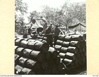 KILIGIA, NEW GUINEA, 1944-03-14. SX39832 SERGEANT J.W. INGE (1), AND VX55524 LIEUTENANT M.A. BLAND (2), OFFICER COMMANDING 8TH FIELD BAKERY PLATOON, AT THE UNIT STORES DUMP INSPECTING FLOUR AND ..