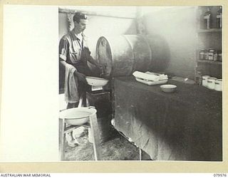 ORO BAY, NEW GUINEA. 1943-07. PRIVATE W.A. CLARINGBOLD, MEDICAL ORDERLY, DRAWING WATER FROM A 44 GALLON STORAGE DRUM IN ONE OF THE WARDS OF THE 10TH FIELD AMBULANCE