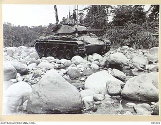 TOROKINA, BOUGAINVILLE, 1945-08-14. AN M24 LIGHT TANK DURING BOULDER CROSSING TESTS IN THE BED ON A RIVER. THE TESTS WERE CONDUCTED BY THE BRITISH WAR OFFICE TRIALS TEAM (TANKS)