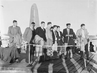 [A group of men in uniform standing on a dock]