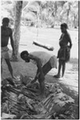 Ambaiat: distribution of pork from pig killed for damaging garden, pig's owner (in shirt) selects piece for waiting woman