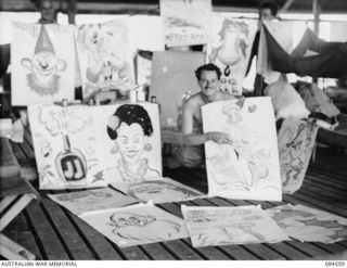 LABU, NEW GUINEA. 1944-12-22. SAPPER D. GORDON, 43 LANDING CRAFT COMPANY, AMONG POSTERS HE HAS COMPLETED FOR CHRISTMAS DECORATIONS AT THE OFFICERS' AND THE OTHER RANKS' MESS