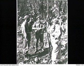 THE SOLOMON ISLANDS, 1945-04-24/27. AUSTRALIAN SOLDIERS HOLDING A DISCUSSION IN A JUNGLE CLEARING ON BOUGAINVILLE ISLAND. (RNZAF OFFICIAL PHOTOGRAPH.)