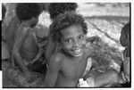 Smiling boy looks at camera, other children in background