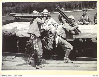 BUKA ISLAND, BOUGAINVILLE AREA, 1945-09-19. JAPANESE NAVAL TROOPS LOADING SWORDS OF JAPANESE OFFICERS, TIED IN BUNDLES OF TEN, ONTO AN AUSTRALIAN MOTOR LAUNCH AT BUKA JETTY, FOR TRANSPORTATION TO ..