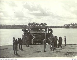 MADANG, NEW GUINEA. 1944-06-27. TROOPS OF THE 7TH DOCKS OPERATING COMPANY UNLOADING AUSTRALIAN ARMY MOTOR VEHICLES FROM AN AMERICAN ARMY LCT (LANDING CRAFT TRANSPORT)