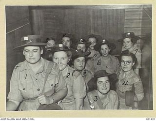 LAE, NEW GUINEA, 1945-05-07. AUSTRALIAN WOMEN'S ARMY SERVICE PERSONNEL FILING UP THE GANGWAY OF THE MV DUNTROON FOR DISEMBARKATION INTO LANDING BARGES ALONGSIDE. THEY ARE PART OF A GROUP OF 342 ..
