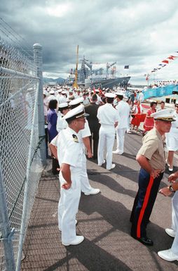 American officers survey the crowd assembled to greet the visiting Chinese training vessel ZHENG HE. The oiler USS CIMARRON (AO 177) is moored behind the ZHENG HE